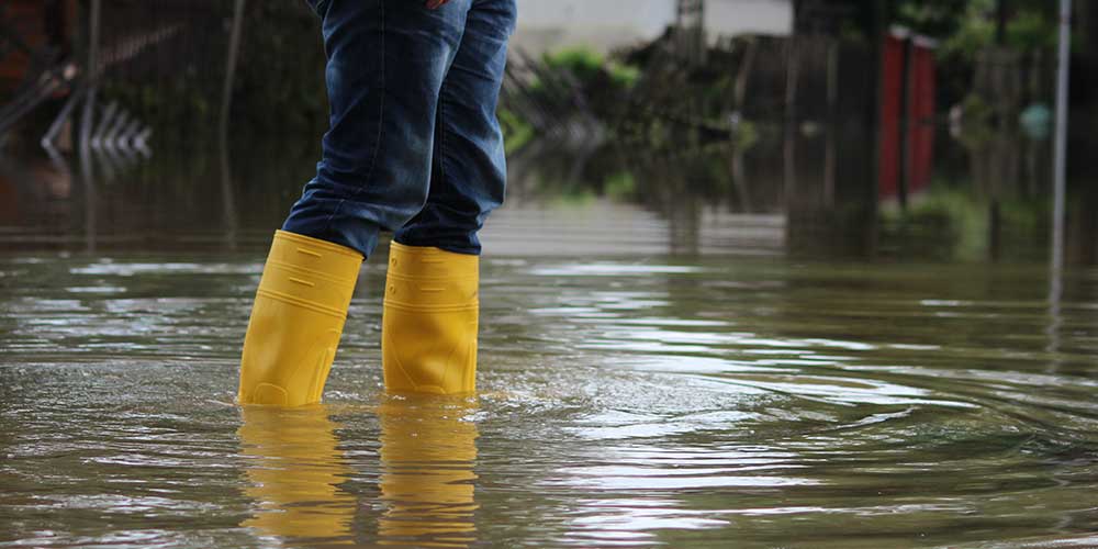 Wearing yellow flood boots walking through flood water